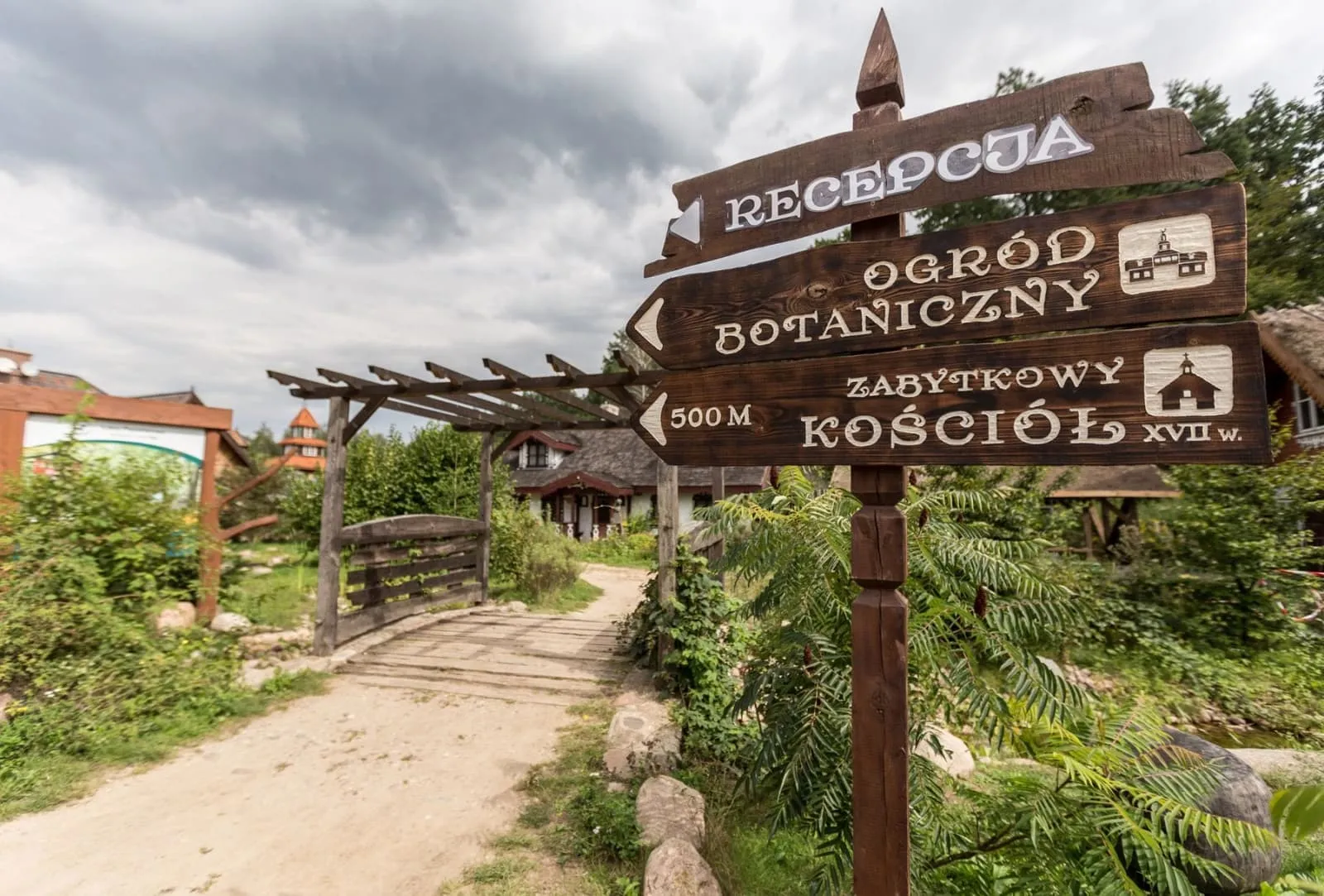 Drogowskaz przy wjeździe: recepcja, ogród botaniczny, zabytkowy kościół